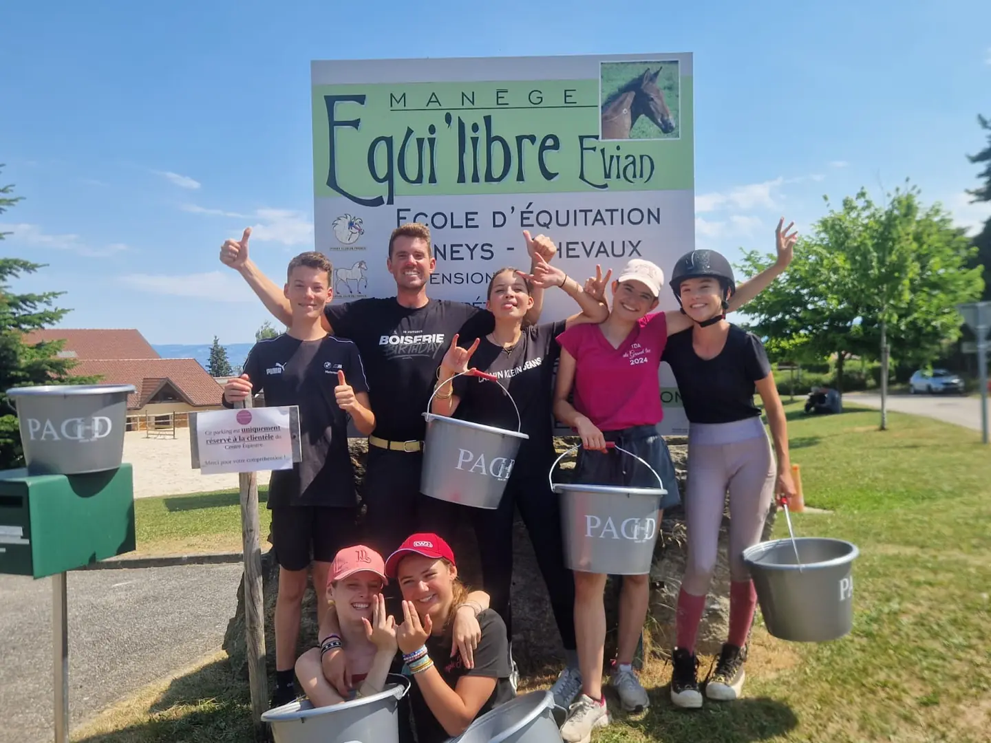 Les jeunes cavaliers et leurs encadrants réunis devant le panneau du club